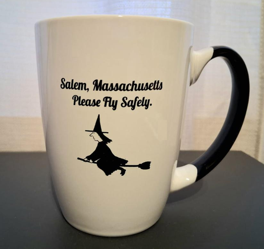 "Salem, Massachusetts" "Please Fly Safely" White, ceramic, 12oz coffee mug with black handle and interior.